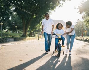 Parents teaching child how to ride bike